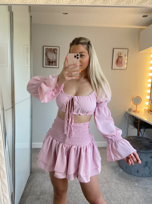 Beautiful baby pink boho style co-ord which features ruffled elasticated skirt and tie front crop top with long elasticated floaty sleeves.